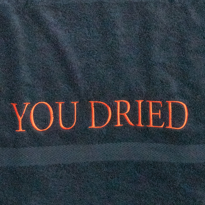 Gros plan sur les lettres "YOU DRIED" brodées en rouge